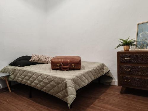 une valise assise au-dessus d'un lit dans l'établissement Hyper-central apartment, à Sète