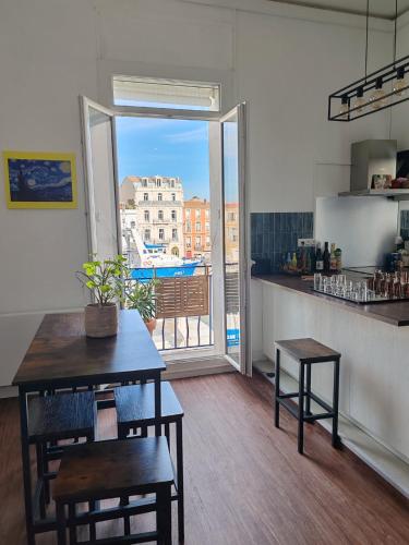 Il dispose d'un balcon et d'une cuisine avec une table et des chaises. dans l'établissement Hyper-central apartment, à Sète