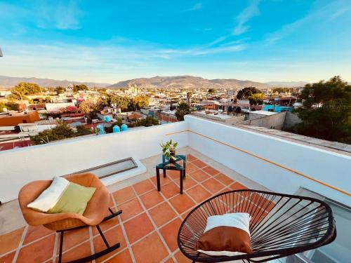 a balcony with chairs and a view of the city at Departamento con terraza en el Centro in Oaxaca City
