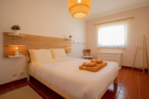 a bedroom with a bed with two towels on it at BE LOST - Guest House in Pedra Do Ouro