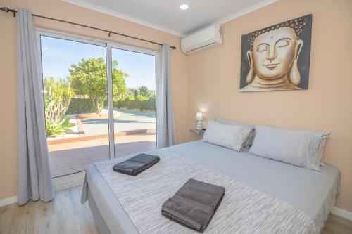 a bedroom with a large bed with a large window at Quinta Gomes in Lagos