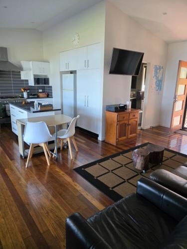 a living room with a table and a kitchen at Russ Vegas in Russell Island