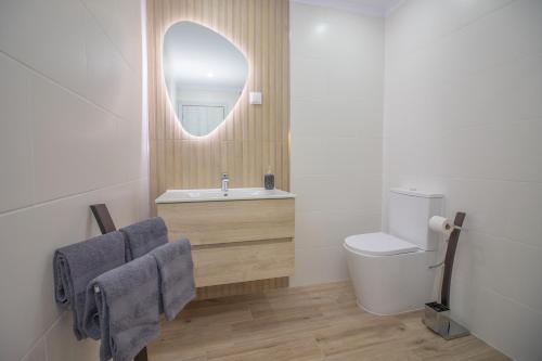 a bathroom with a sink and a toilet and a mirror at Quinta Gomes in Lagos