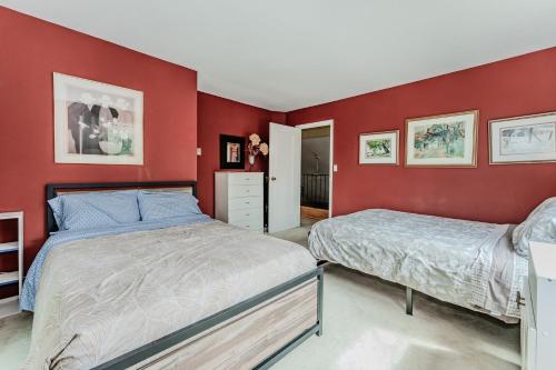 two beds in a bedroom with red walls at Artistic Haven By The Beach in Wiarton