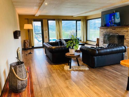 ein Wohnzimmer mit Ledermöbeln und Kamin in der Unterkunft Casa Patagonia in San Martín de los Andes