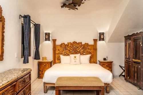 ブセリアスにある5 Frogs Hotel Buceriasの木製のヘッドボードが付いた大きなベッドのある寝室