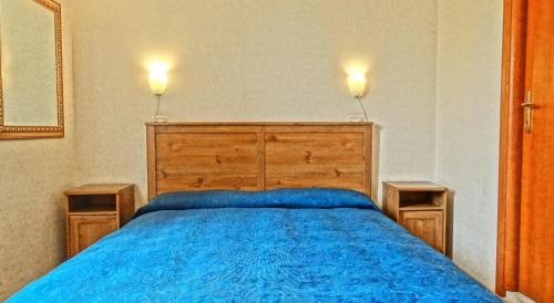 a bedroom with a blue bed with two lights on top at Gite House in Rome