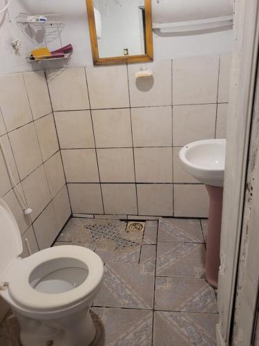 a bathroom with a toilet and a sink at Tatiane cristino in Imbituba