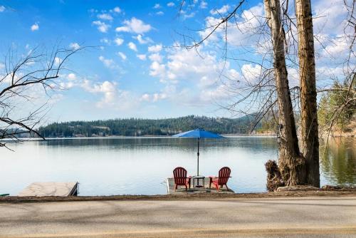 zwei Stühle und ein Tisch mit einem Sonnenschirm auf einem See in der Unterkunft Hauser Haven in Hauser