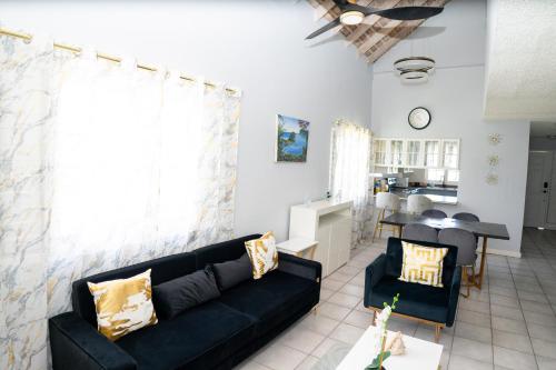 a living room with a black couch and a table at Dejai On The Bay in Montego Bay