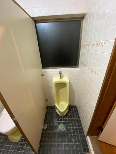 a bathroom with a urinal and a toilet at 勝山貸切民泊三つ子の魂 福井県立恐竜博物館まで車で10分 発坂駅から徒歩5分 in Katsuyama