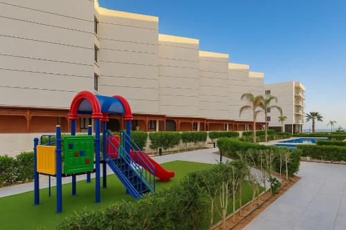 a playground in front of a building at Discover Tranquility by the Sea at Porto Said Resort in Port Said