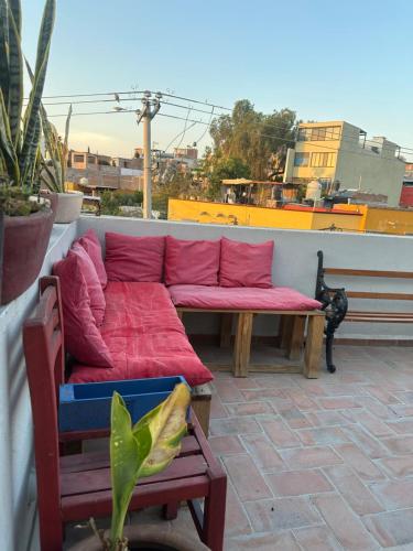 a red couch sitting on top of a balcony at Santa Noche Suite & Spa in San Miguel de Allende