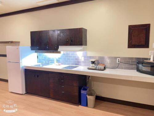 a kitchen with wooden cabinets and a white refrigerator at Wells Gray Inn in Clearwater