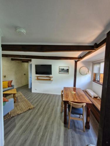 a living room with a wooden table and a tv at The Bullock & Bridle Retreat at 58 in Mintaro