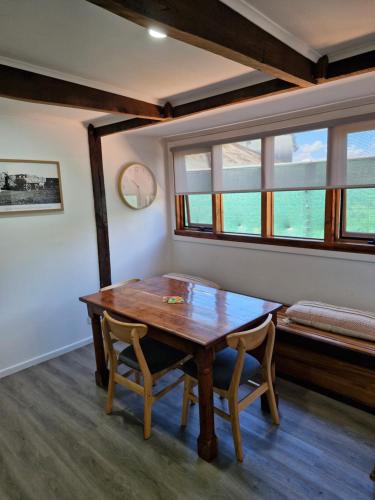 a dining room with a wooden table and two chairs at The Bullock & Bridle Retreat at 58 in Mintaro