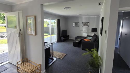 a living room with a couch and a chair at Hillcrest Hideaway in Rotorua