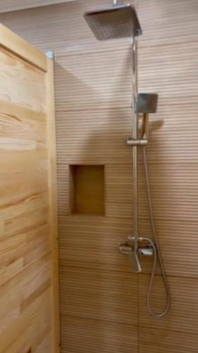 a shower in a bathroom with a wooden wall at Rafting Tara Camp Highlander in Bastasi