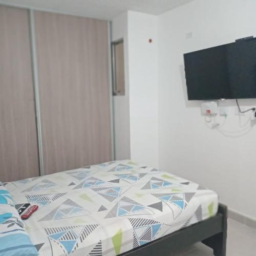 a bedroom with a bed and a flat screen tv at APARTAMENTO VALLEDUPAR - Ventilador in Valledupar