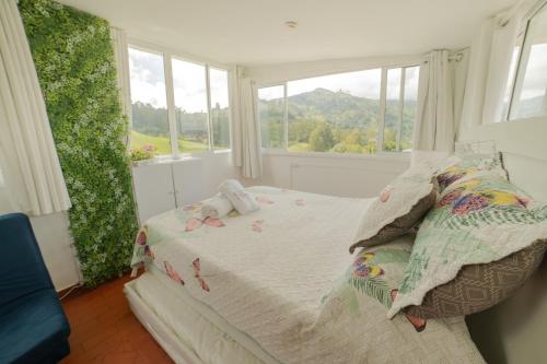 a bedroom with a bed with a view of a mountain at Posada del Angel in Salento