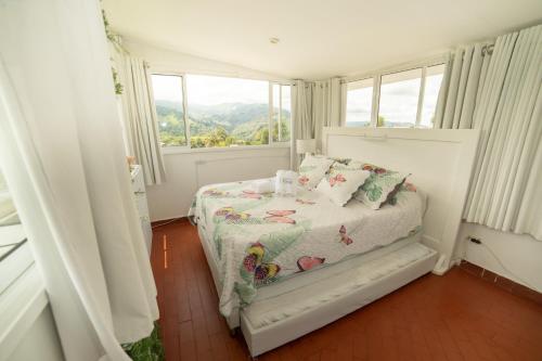 a small bedroom with a bed with a window at Posada del Angel in Salento