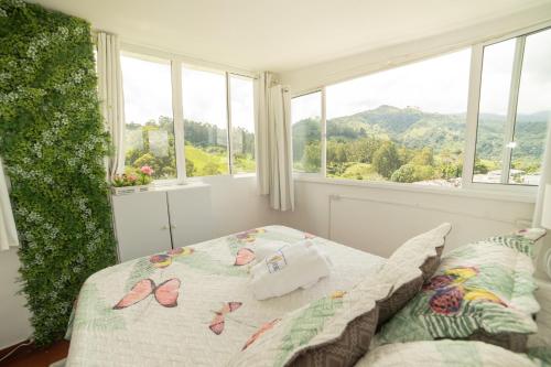 a bedroom with a bed with a view of the mountains at Posada del Angel in Salento