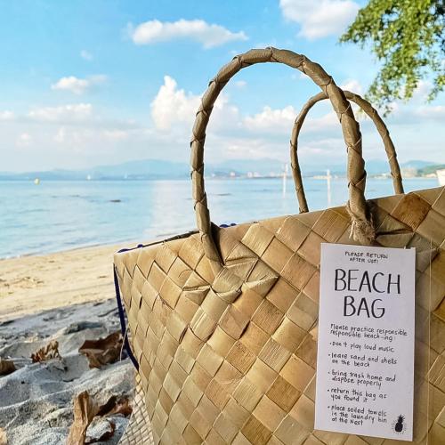 a beach bag sitting on the beach with a sign on it at UMI Nest Apartment in Subic Bay with Self-Serve Breakfast - WiFi, Bathtub, Barbecue, Pet Friendly with a Fee in Santa Rita