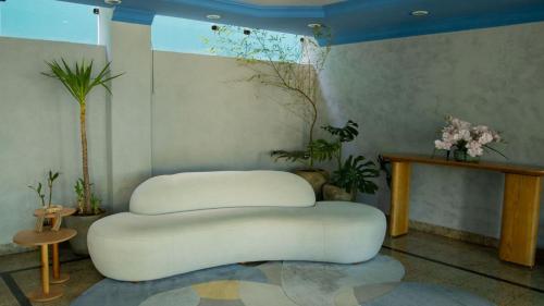 a white bench in a room with flowers on the wall at Abbas Hotel in Uberlândia