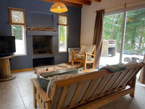 a living room with a couch and a tv at La Amapola in Villa La Angostura