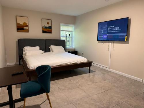 a bedroom with a bed and a flat screen tv at Cosy Bedroom 6 minutes to EWR Prudential Hotels Pen station in Newark