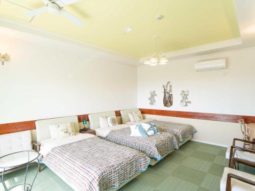 two beds in a room with white walls at Auberge Bonne Chere Raout in Onna
