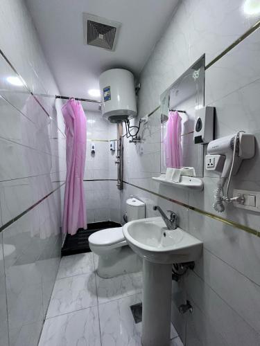 a white bathroom with a sink and a toilet at Abdeen Cairo Hostel in Cairo