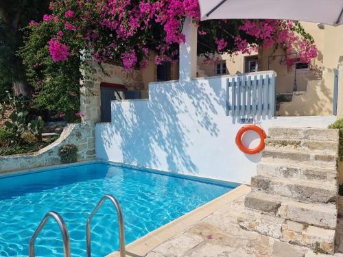 a swimming pool in a villa with pink flowers at Blue Note House in Asos