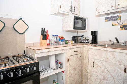 a small kitchen with a stove and a sink at Nadiyah's Escape in Rock Sound