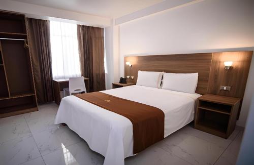 a hotel room with a large bed and a table at Las Torres Hotel Boutique in Moquegua