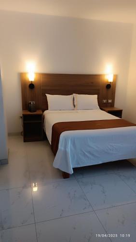 a bedroom with a large bed and two night stands at Las Torres Hotel Boutique in Moquegua