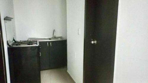 a black and white kitchen with a sink and a counter at Hotel Blue in Santa Rosa de Cabal