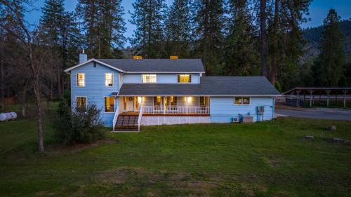 a white house with lights on in a yard at Pool-GameRoom-HomeTheater-Bar-PlayStructure-FirePit in Oakhurst