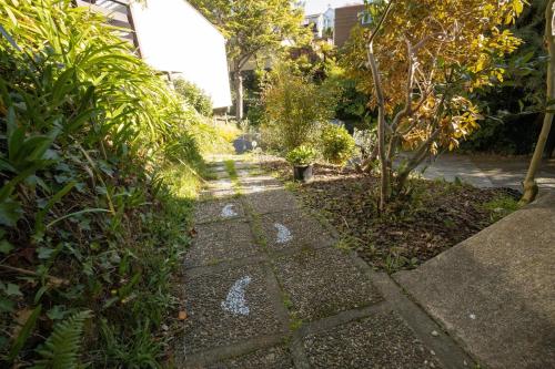 a garden with a stone walkway with trees and plants at big sale was 258 now from 138 for 2or3 bedrooms in Wellington