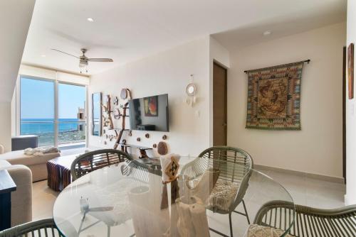 a living room with a glass table and chairs at Tree House Akumal Sea View Walk To Beach 11 Pools in Akumal