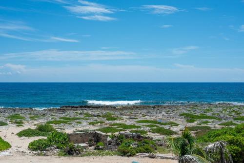 a rocky beach with the ocean in the background at Tree House Akumal Sea View Walk To Beach 11 Pools in Akumal