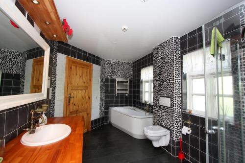 a bathroom with a sink and a toilet and a tub at Guesthouse Storu-Laugar in Laugar