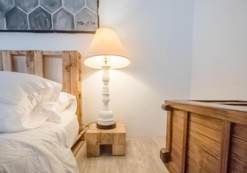 a lamp sitting on a table next to a bed at FOREST and OCEAN Nest with Self-Service Breakfast - AC, Monkeys, Pet Friendly with a Fee in Subic Bay Intl