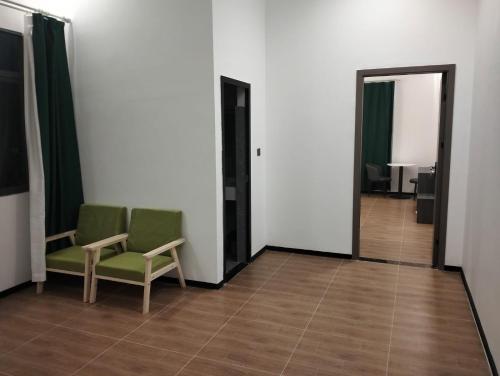 a room with two chairs and a hallway with two doors at Rainforest Hotel in Paksong