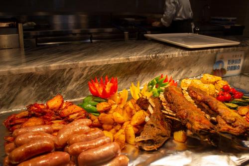 a buffet of food with sausage and other foods at Shangrao International Hotel in Shangrao