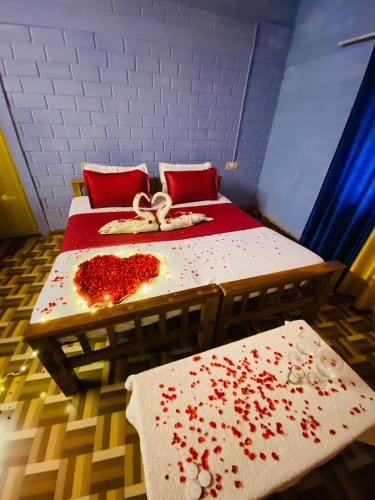 a room with two beds with red flowers on it at Paradise Inn Beach Resort in Varkala