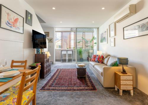 a living room with a couch and a table at Elegant Apartment, Heart of Newtown with Secure Parking in Sydney
