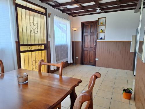 a dining room with a wooden table and chairs at Casa Vacacional floreva in Tapantí