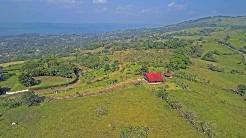 an aerial view of a farm on a hill with a red roof at Casa Vacacional floreva in Tapantí
