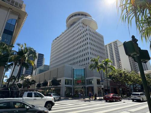 a large building on a city street with cars at First Cabin International Hawaii in Honolulu